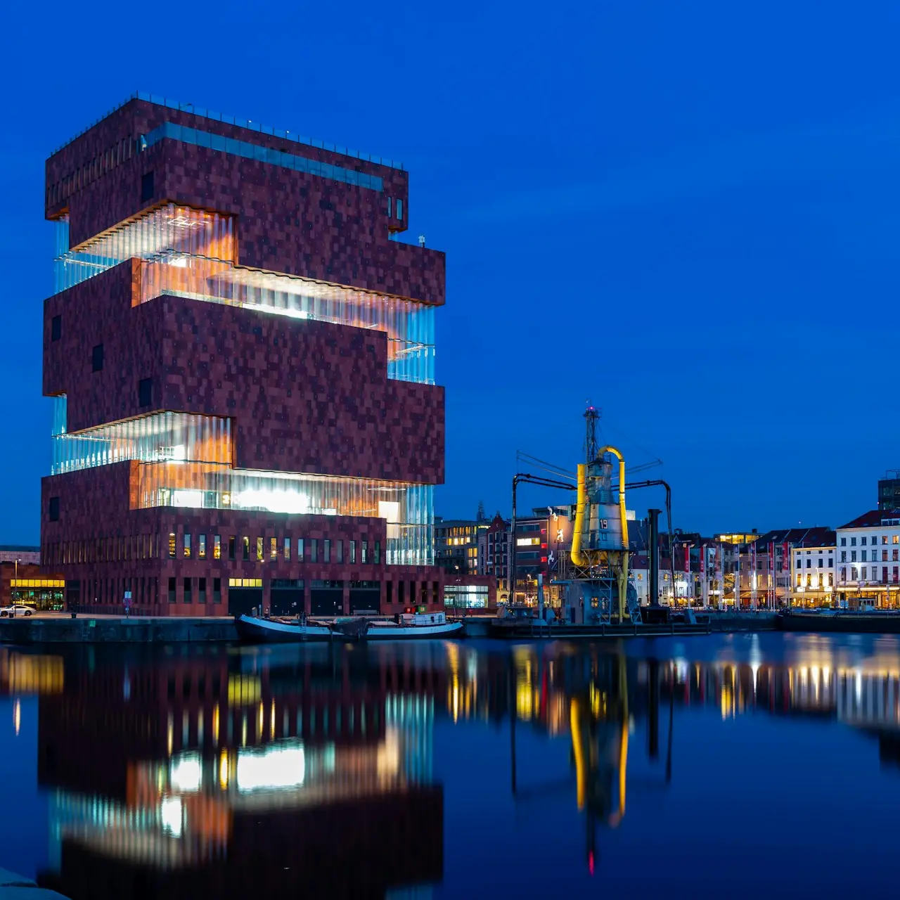 brown concrete building near body of water during night time