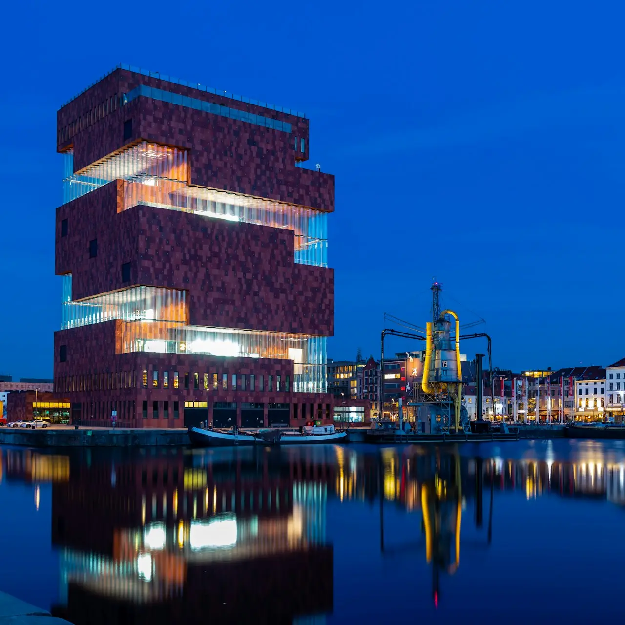 brown concrete building near body of water during night time